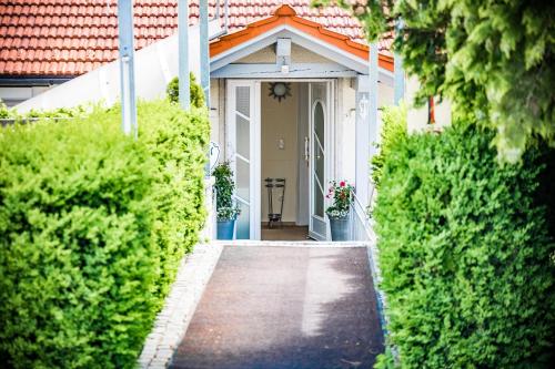 a white house with an orange roof and a walkway at Hotel Der Seehof in Hauzenberg