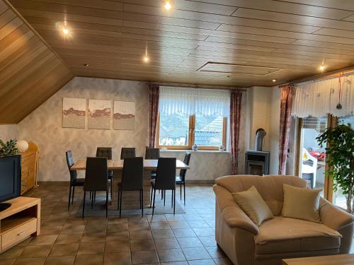 a living room with a couch and a table and chairs at Ferienhaus Nicole in Piesport