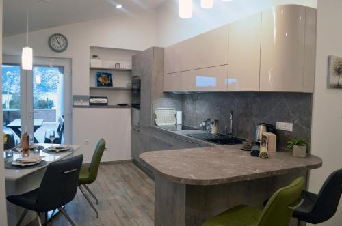 une cuisine avec un comptoir, une table et des chaises dans l'établissement Apartments Rina - Kneže, à Račišće