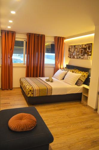 a bedroom with a large bed with orange curtains at Apartments Rina - Kneže in Račišće