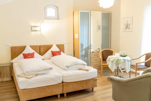 1 Schlafzimmer mit 2 Betten, einem Tisch und einem Stuhl in der Unterkunft Hotel Der Seehof in Hauzenberg