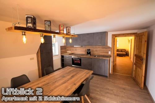 a kitchen with a wooden table and a dining room at Ferienwohnungen "Liftblick 2 oder 3" im Kurort Altenberg in Kurort Altenberg