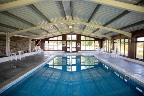 una piscina coperta con un grande soffitto di Jasmine Cottage a Bude