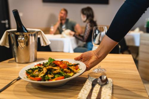 a person holding a plate of food on a table at B&B La Siesta in Markovci