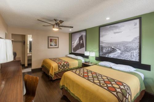 a hotel room with two beds and a large screen at Super 8 by Wyndham Austin University/Downtown Area in Austin