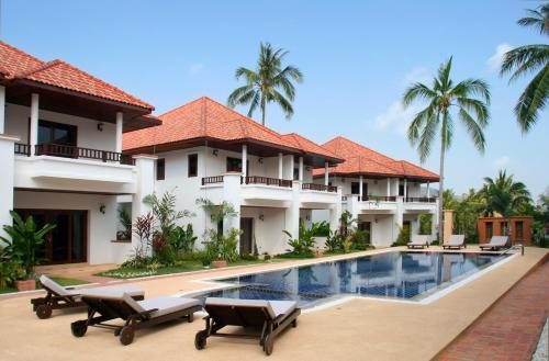 a villa with a swimming pool and palm trees at The Gardens in Bangrak Beach