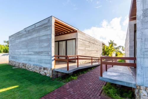 a small building with two benches on a lawn at Bahay Tatu in Pôrto de Pedras