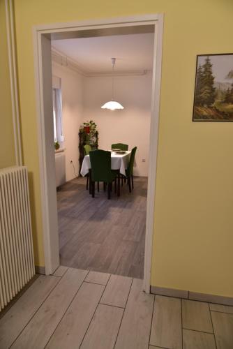a dining room with a table and green chairs at Primula Apartment in Blejska Dobrava