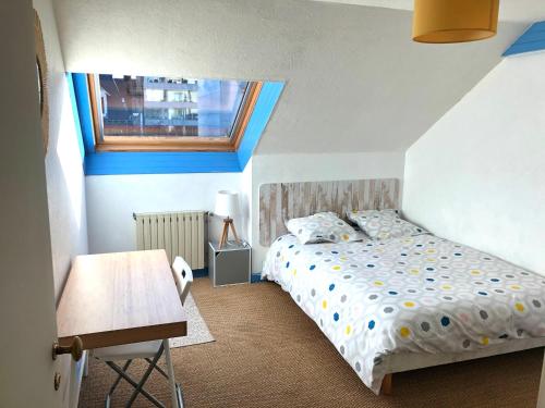 - une chambre avec un lit, un bureau et une fenêtre dans l'établissement Grand et Charmant 3 pièces Breton Saint Brieuc Centre, à Saint-Brieuc