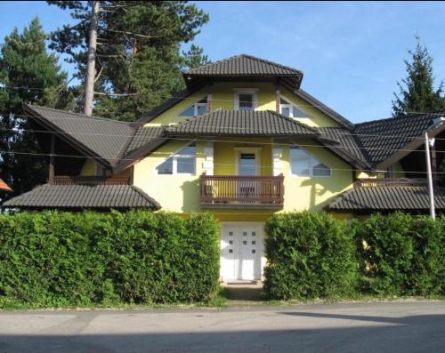 a yellow house with a black roof and bushes at Yellow House in Palisad