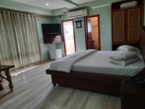 a bedroom with a large bed and a television at Hotel Rains Inn in Guwahati