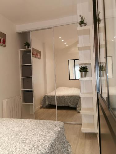 une chambre avec un miroir et un lit dans une pièce dans l'établissement Le Bruxelles, 1 Chambre, Rez de Chaussée, Terrasse Sud, à Le Touquet-Paris-Plage