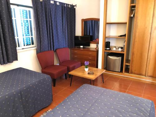 a room with a bed and a table and a desk at Casa GiGi in Sagres