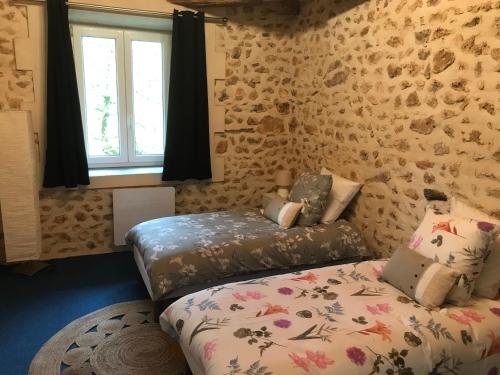 1 dormitorio con 2 camas y ventana en La Grenouille, en Saint-Adjutory