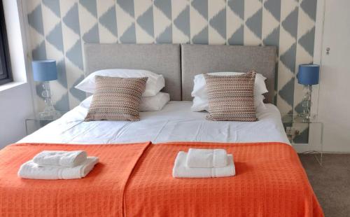 a bedroom with a bed with two towels on it at Bell Lodge in Chichester