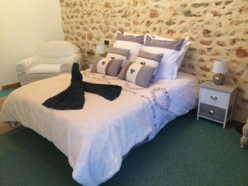 a bedroom with a bed with white sheets and pillows at La Grenouille in Saint-Adjutory