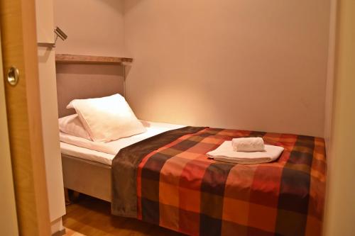 a small bedroom with a bed with two towels on it at Levi Suites Levin Klubi in Levi