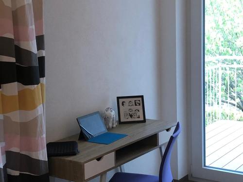 a desk with a laptop on it next to a window at Time Out Apartments in Herzogenaurach