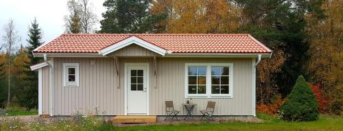 a small house with a table and chairs in it at Nybyggd stuga intill skogsbrynet - New built cottage next to the cowberry forest in Mora
