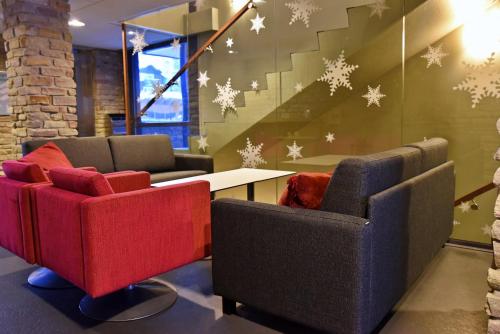 a lobby with two chairs and a table and a staircase at Levi Suites Levin Klubi in Levi