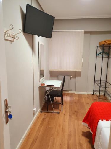 a room with a desk and a table with a chair at Pensión El Espolón in Logroño