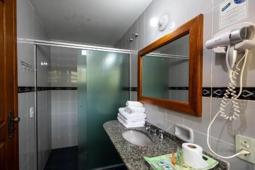 a bathroom with a shower and a sink and a mirror at Canzi Cataratas Hotel in Foz do Iguaçu