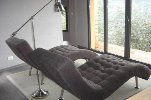 a chair in a living room with a lamp at beautiful cottage with pool: 8 pers in Isolabona