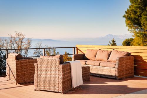 two wicker chairs and a couch on a balcony at Villa Yanko, large pool stunning sea view in Tučepi