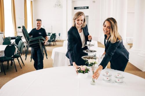 two women are standing around a white table at Thermae Palace in Ostend
