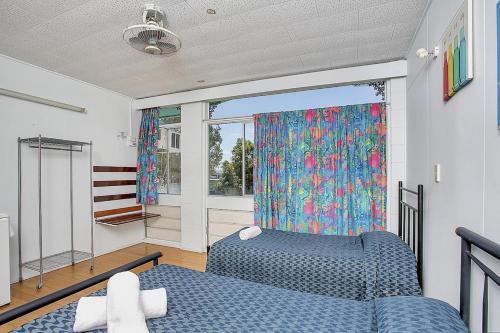 a bedroom with two beds and a window at Caravella Backpackers in Cairns