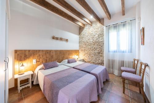 - une chambre avec un grand lit et un mur en pierre dans l'établissement Holiday Home Florence, à Ampurias