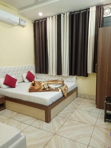 a bedroom with a bed with red pillows on it at Hotel vinayak inn in Haridwār