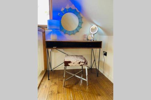 a dressing table with a chair and a mirror at Winterberry Barn in Romsey