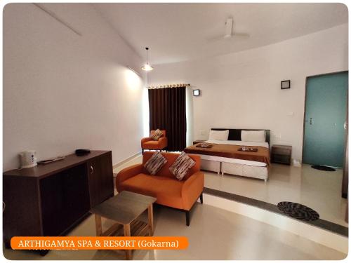 a living room with a bed and a couch and a room with a bed at Arthigamya Beach Front Resort & SPA in Gokarna