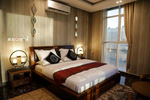 a bedroom with a large bed and a window at Arto Aparthotel in Riyadh
