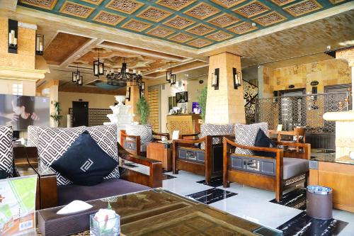 a living room with chairs and tables in a room at Arto Aparthotel in Riyadh