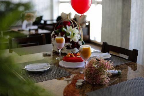 a table with two glasses of orange juice and a balloon at Arto Aparthotel in Riyadh