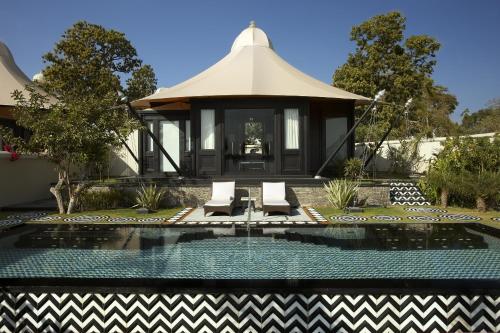 a villa with a swimming pool and a pavilion at The Leela Palace Udaipur in Udaipur