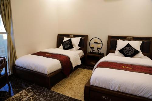 a hotel room with two beds and a mirror at Arto Aparthotel in Riyadh