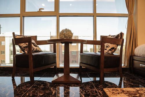 a dining room with a table and two chairs and a window at Arto Aparthotel in Riyadh