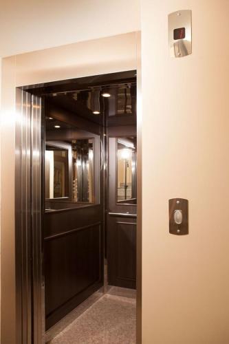 a hallway with a door with a speaker on a wall at Hotel Motto in Stara Zagora