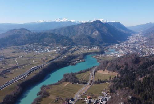 an aerial view of a river with mountains at Primula Apartment in Blejska Dobrava