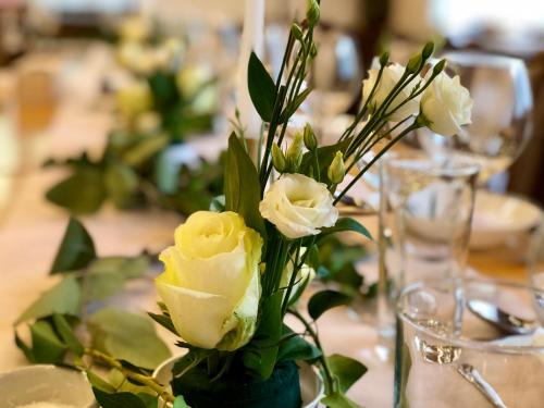 a vase filled with yellow roses on a table at Zseri Vadászház in Fehérvárcsurgó