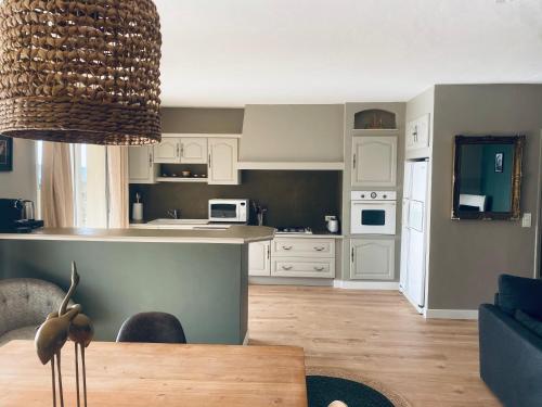 cocina y sala de estar con mesa de comedor en Le Jas de Joucas Hôtel-Restaurant, en Joucas