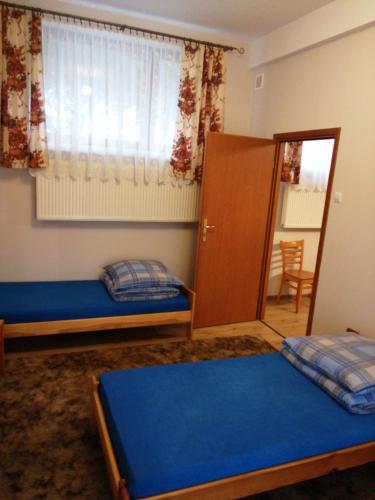 a bedroom with two beds and a cabinet and a window at Alfa 2 apartament 3 in Bystra
