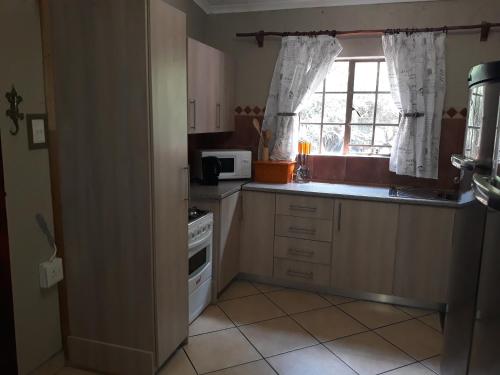 a small kitchen with a stove and a window at Bellamia in Marloth Park