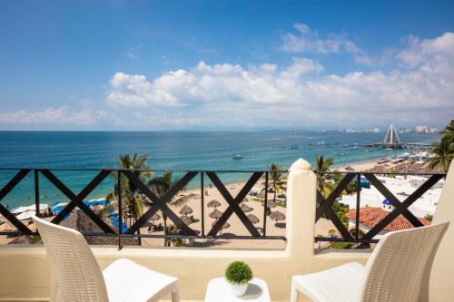 a view of the beach from the balcony of a resort at Blue Chairs Resort by the Sea - Adults Only in Puerto Vallarta