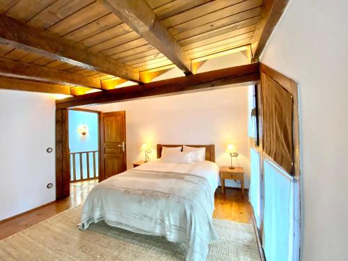 - une chambre avec un grand lit et un plafond en bois dans l'établissement Rustic Chic de Luxe 55C, au Tarter