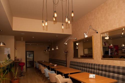 un restaurante con mesas de madera, sillas y espejos en Hotel Motto en Stara Zagora