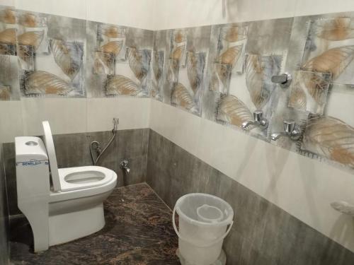 a bathroom with a toilet and bread on the wall at Hotel vinayak inn in Haridwār